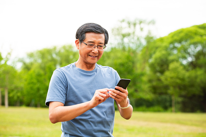 老年男人户外公园使用手机图片下载